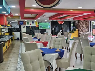 Interior del comedor con la barra del buffet a la derecha y las pantallas al fondo