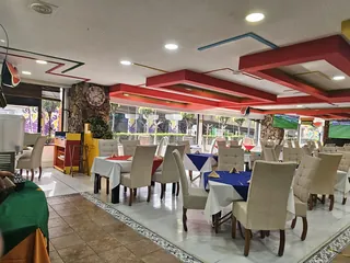 El salón desde la entrada, con las mesas vestidas y el suelo de mosaico
