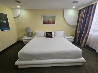 Suite Imperial: cama vestida en blanco, cortinas y alfombra verde