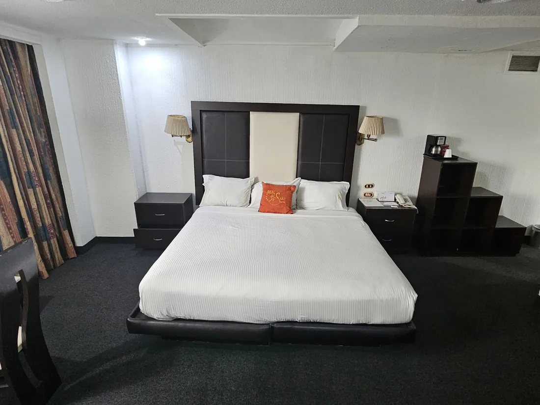 Suite Presidencial: cama King con cabecera de madera oscura